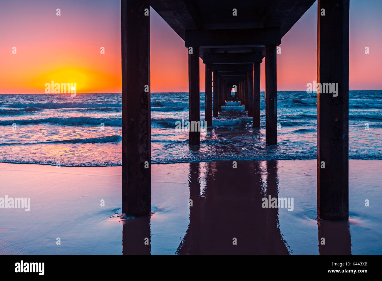 Sonnenuntergang betrachtet unter Brighton Pier, South Australia Stockfoto