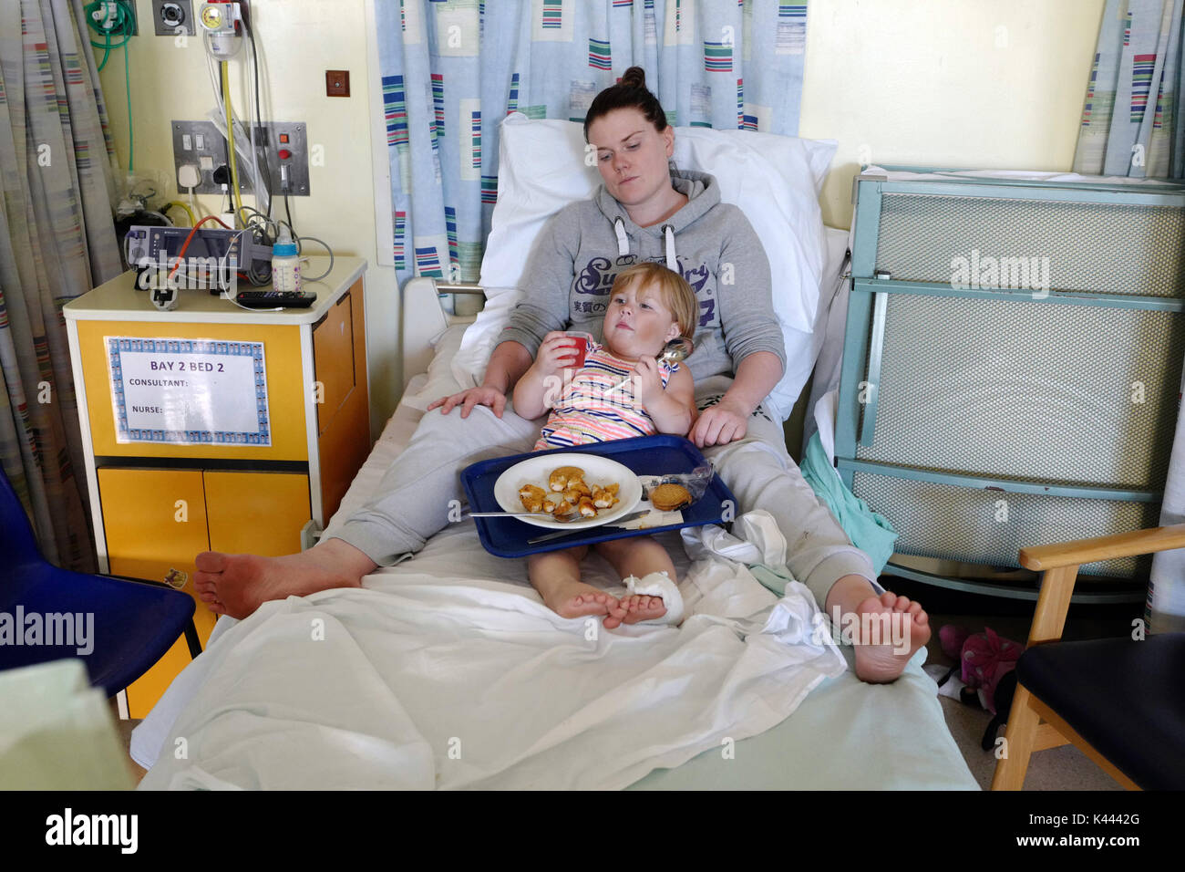 Eine Mutter versucht, ihr Kind im Krankenhaus zum Essen zu bringen. Stockfoto