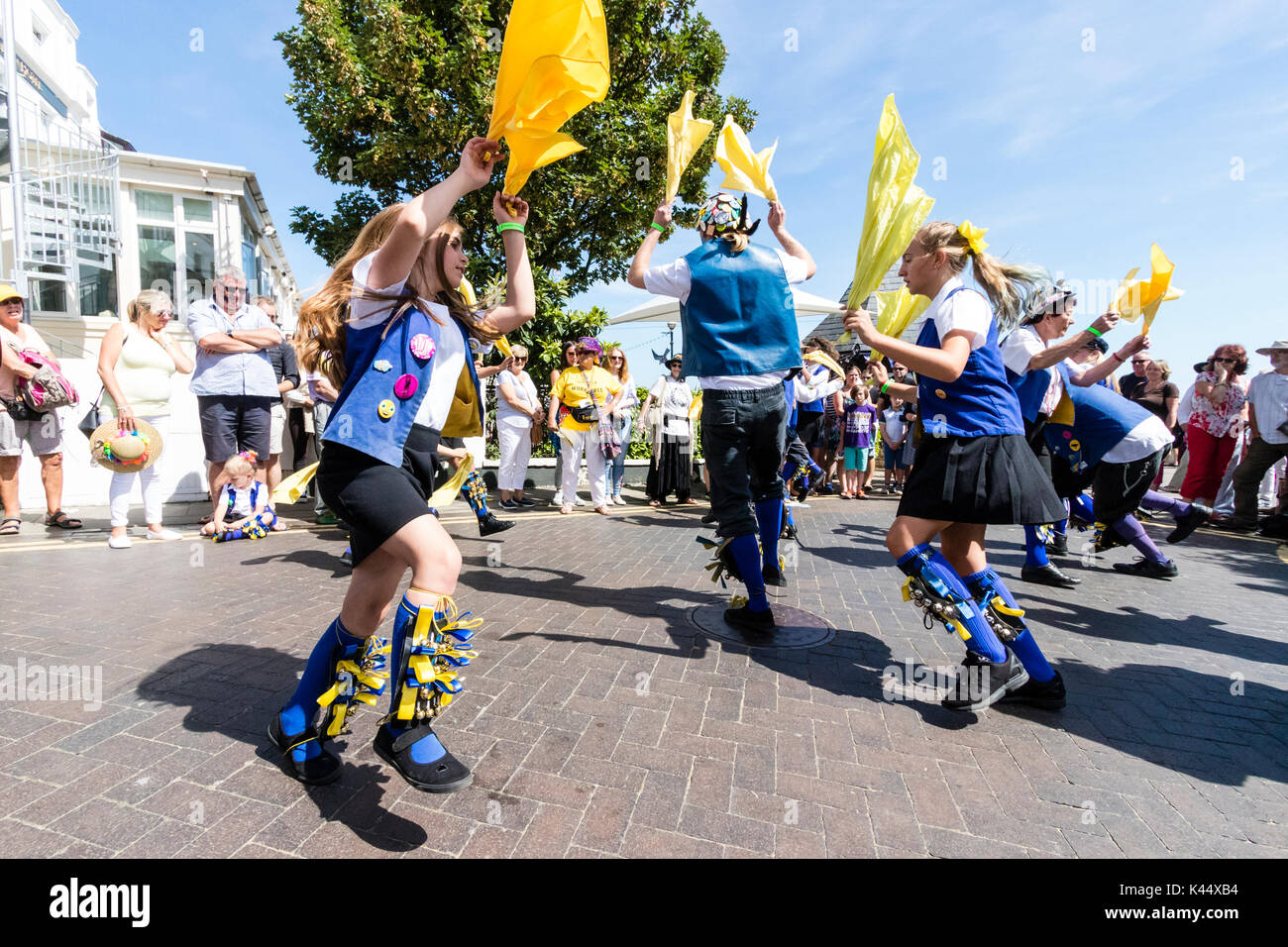 Tradition Volkstänzer, Royal Liberty Morris Männer, ihre blau-weiß und schwarz Kostüme tragen, Tanzen in öffentlichen Platz beim Wellenartig bewegen gelb Taschentücher. Stockfoto