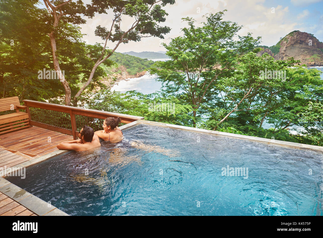 Hispanic Paar in Spa Pool an sonnigen Natur Hintergrund Stockfoto