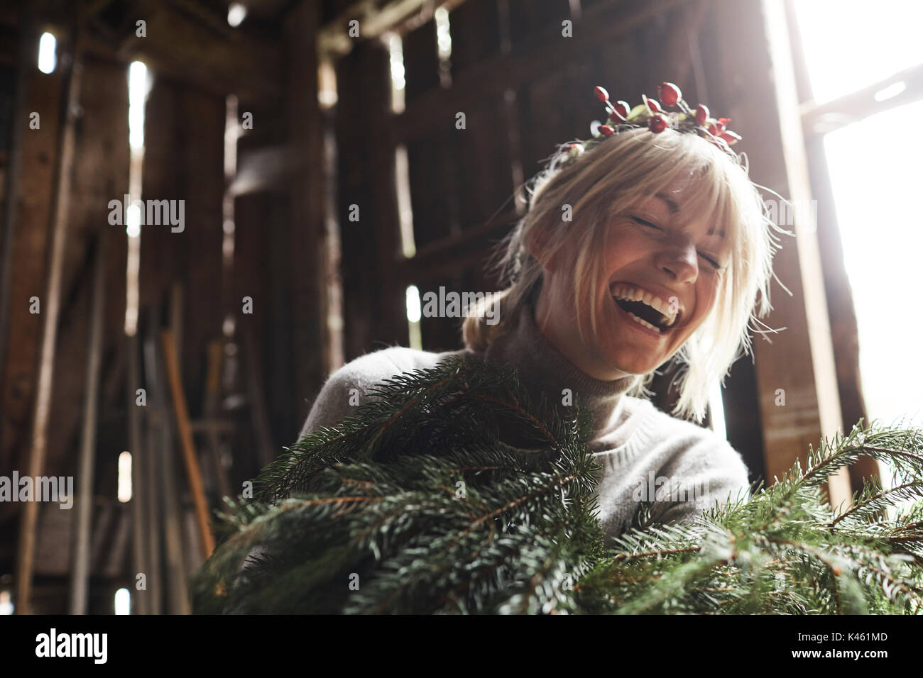 Blonde Frau, Kopfschmuck, Girlande mit Hagebutten, Zweige von Evergreens für Dekoration, Lachen, Porträt Stockfoto