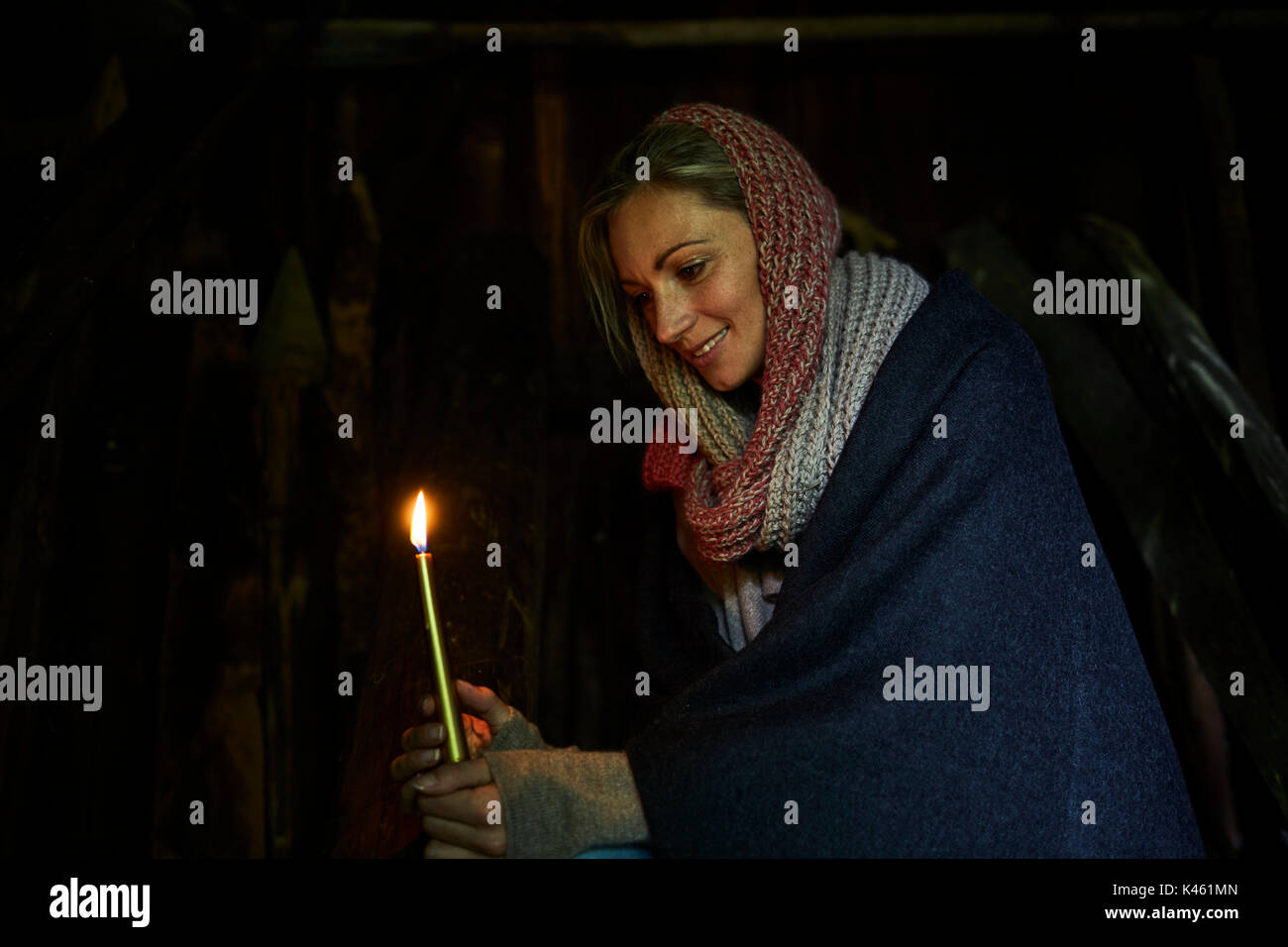 Blonde Frau hält eine Kerze, lächelnd, Seitenansicht, halb-Porträt, Stockfoto