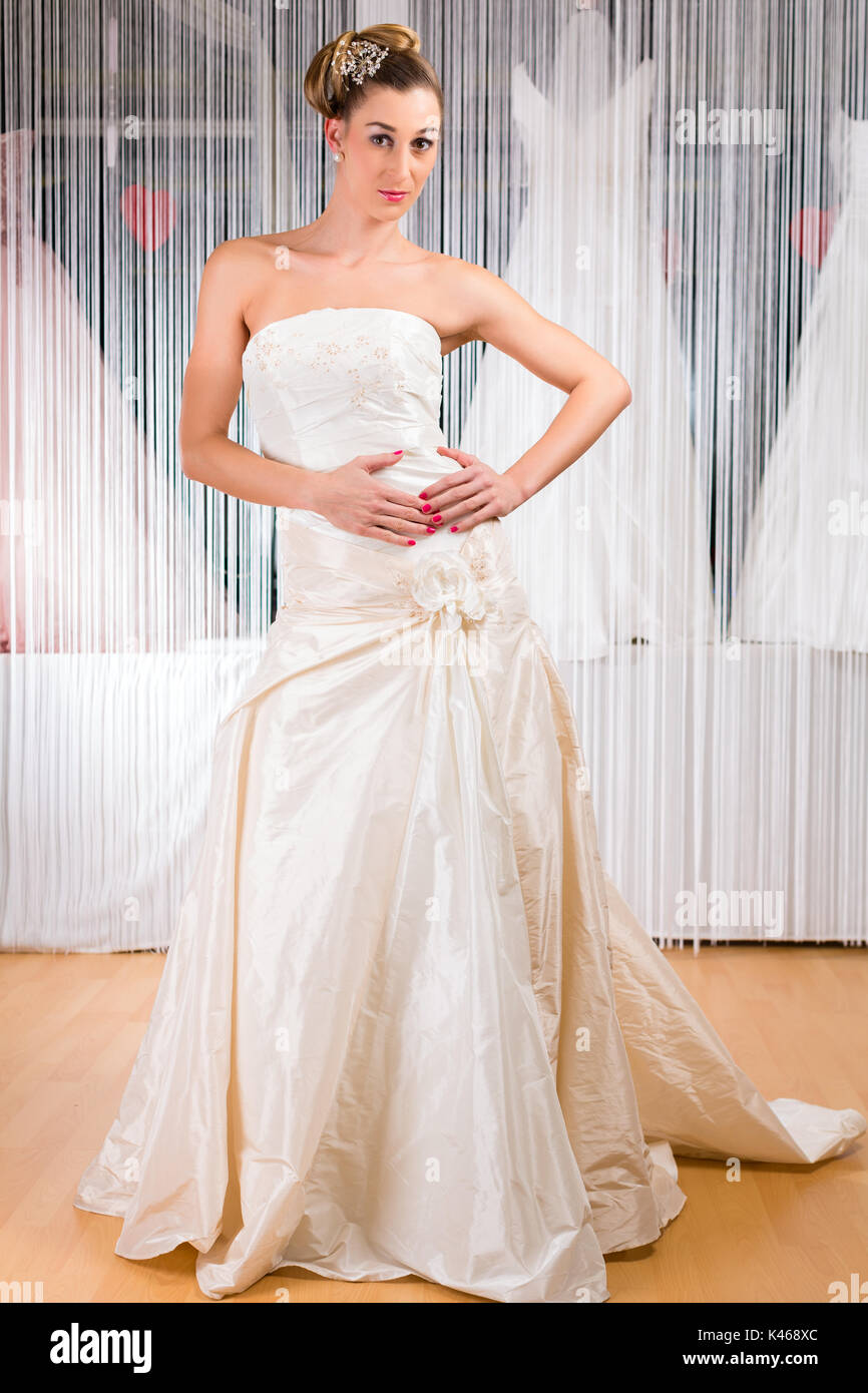 Frau, die versucht, Hochzeit Kleid im Shop Stockfoto