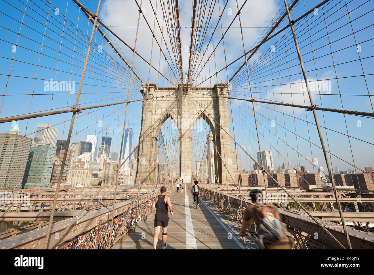 Brooklyn Bridge an einem sonnigen Morgen mit Menschen Laufen und Radfahren in New York Stockfoto