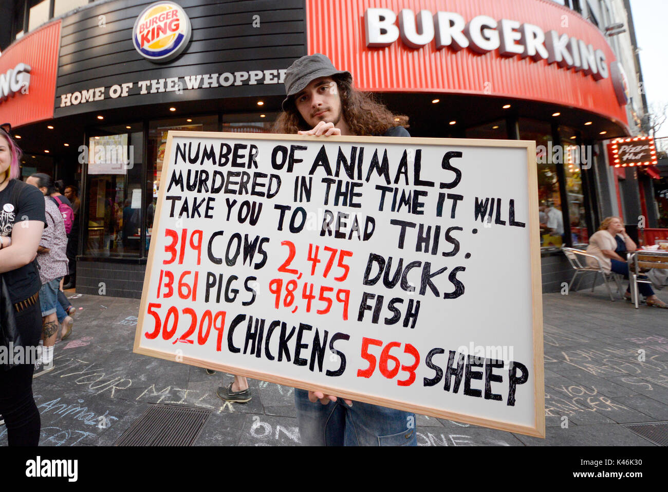 Tierschützer außerhalb der Burger King in Leicester Square, London protestiert. Schock Taktik Plakat Stockfoto