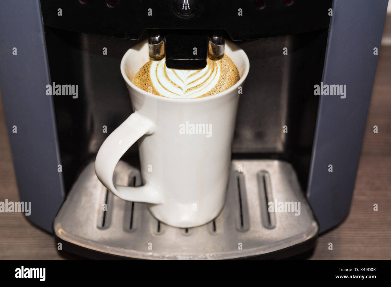 Büro Kaffeemaschine, professionelle Maschine mit einem Becher Kaffee nach Latte Art. Stockfoto