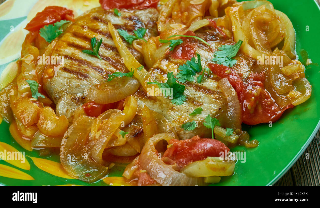 Schweinekoteletts alla Pizzaiola, saftige Schnitzel in eine Italienische Soße mit Tomaten, Zwiebeln gekocht sind, Kräuter der Provence und rote Paprika Flocken Stockfoto