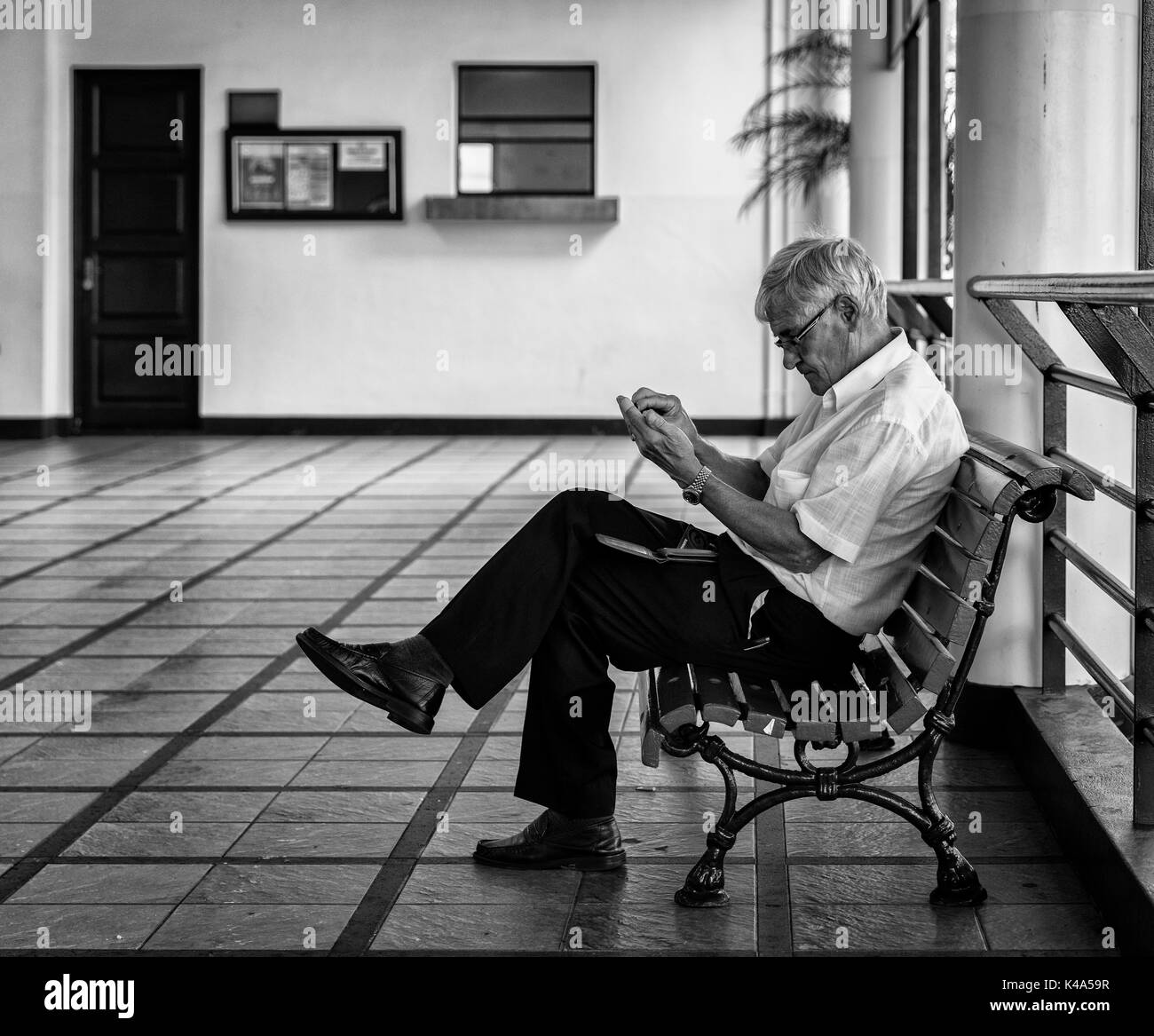 Senior auf EINER Holzbank in EINER Markthalle in Madeira Stockfoto
