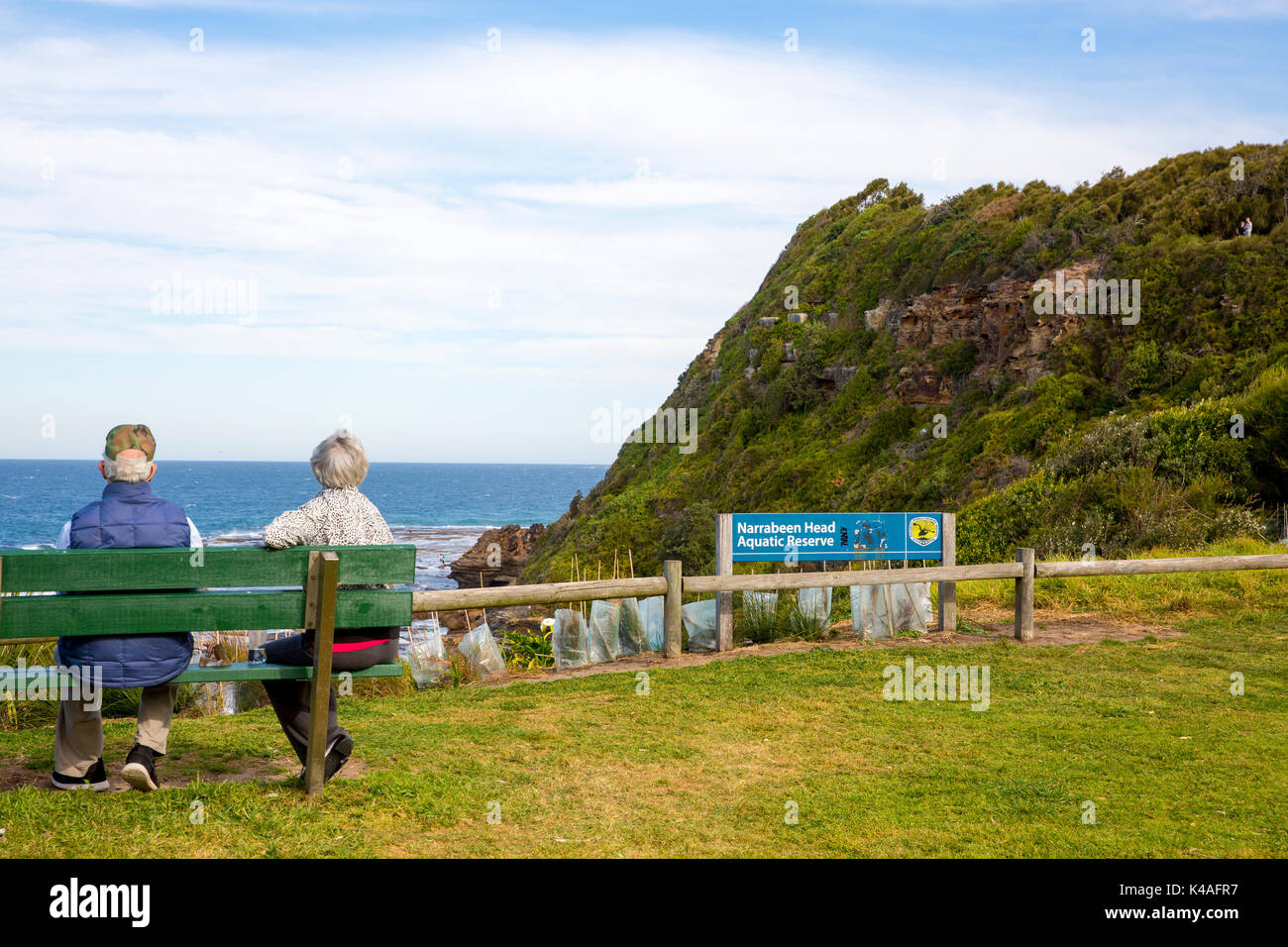 Ältere Paare zusammen auf einer Bank sitzen an der Küste mit Blick auf den Ozean in Sydney, Australien im Ruhestand Stockfoto