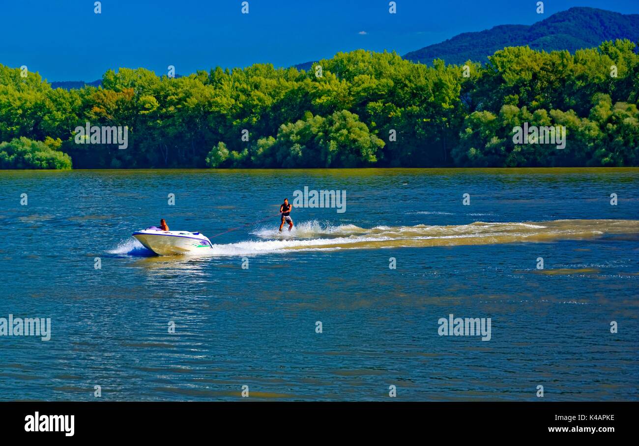 Motorboot zieht Watercraft auf der Donau zum Donauknie Stockfoto