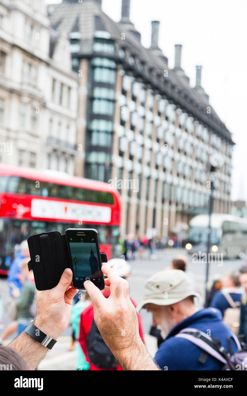 London, Großbritannien. Ein Mann nimmt ein Foto von Big Ben mit einem fotohandy am Parliament Square. Stockfoto