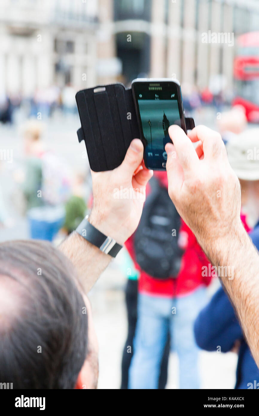 London, Großbritannien. Ein Mann nimmt ein Foto von Big Ben mit einem fotohandy am Parliament Square. Stockfoto