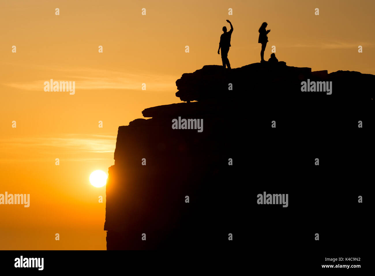 Mann und ein Mädchen auf einer Klippe, den Sonnenuntergang geniessen, wobei ein selfie mit Handy Kameras, Pulpit Rock Stockfoto