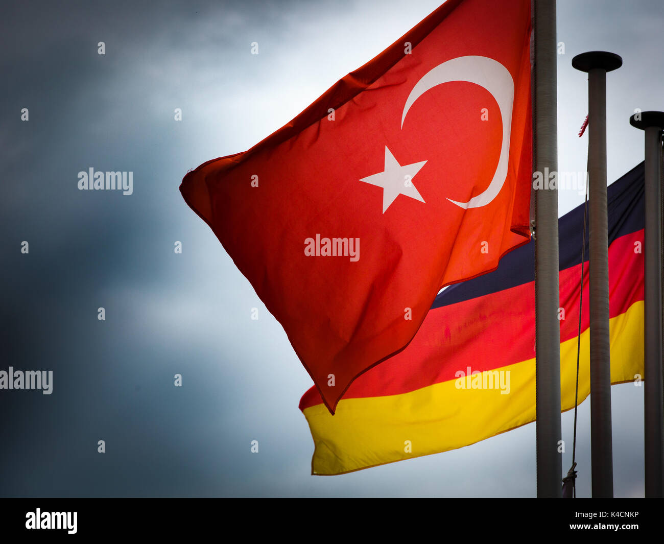 Deutsche und türkische Nationalflagge nebeneinander Vor Gewitterwolken Stockfoto