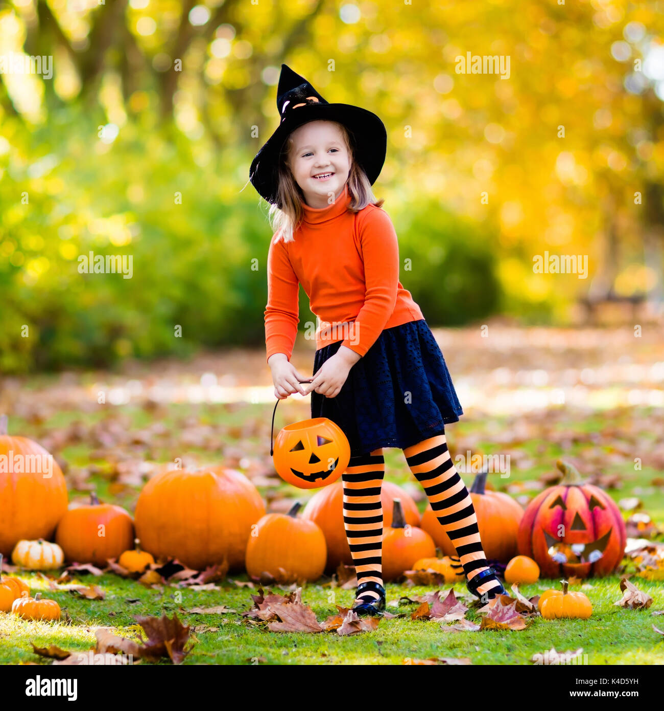 Kinder mit Kürbis an Halloween. Kleines Mädchen in Hexe Kostüm und Hut  spielen im Herbst Park. Kind an Halloween Trick oder Festlichkeit. Kid  Süßes oder Saures Stockfotografie - Alamy