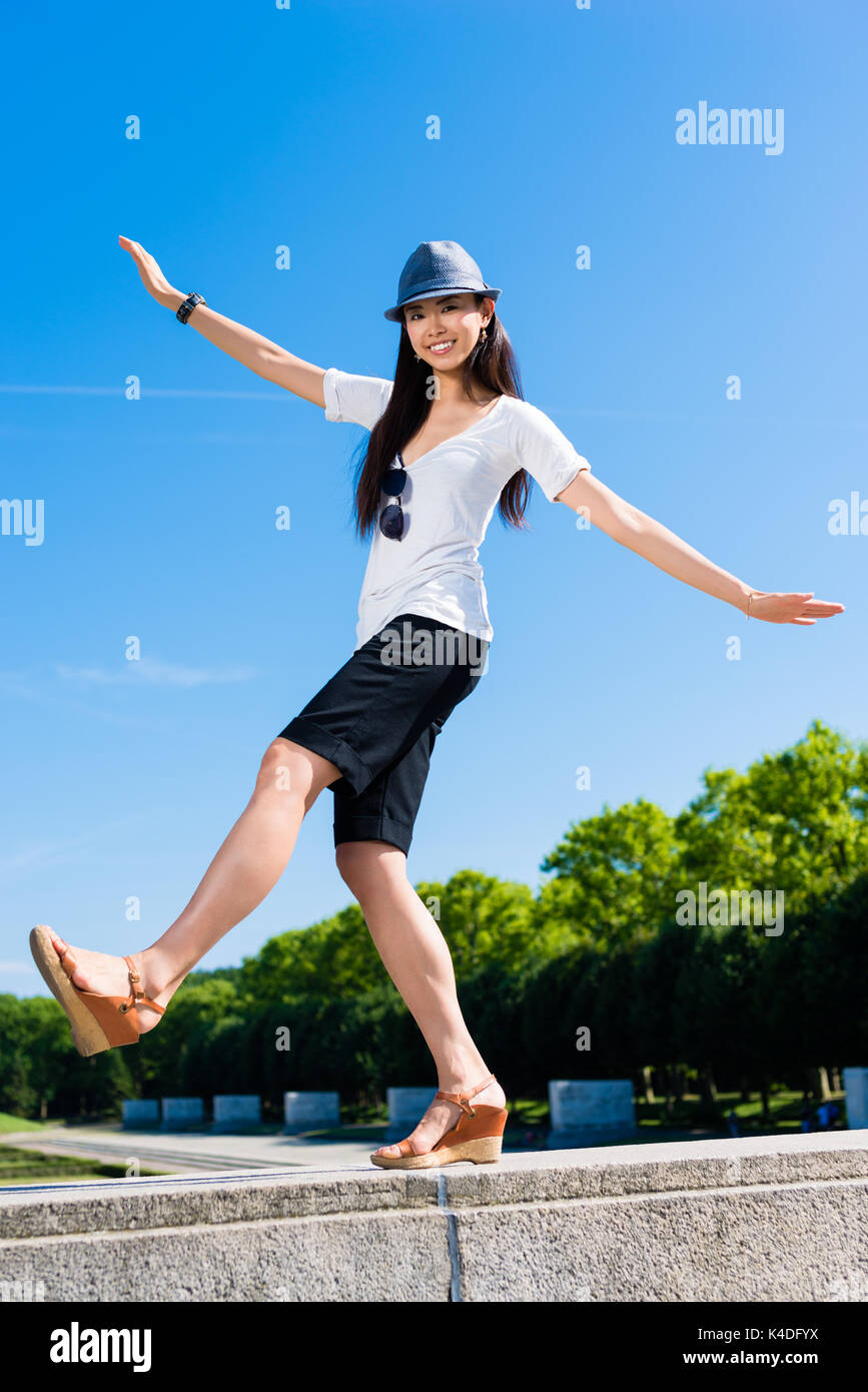 Asiatische Frau Stehen auf einem Bein im Freien Stockfoto