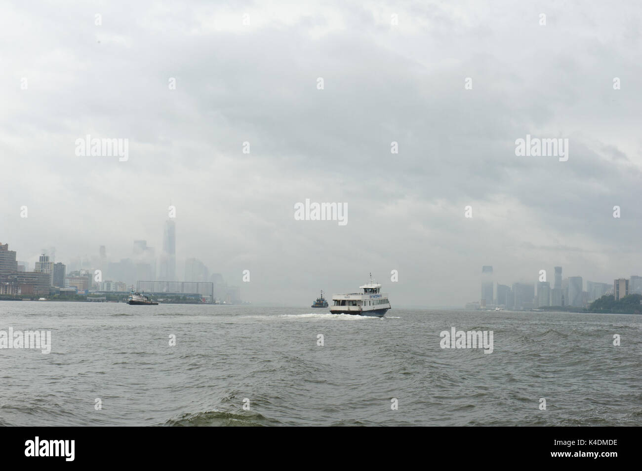 Ein New York Waterway ferry Geschwindigkeiten über den Hudson River Vergangenheit Jersey City und Lower Manhattan an einem regnerischen Tag Anfang September. Stockfoto