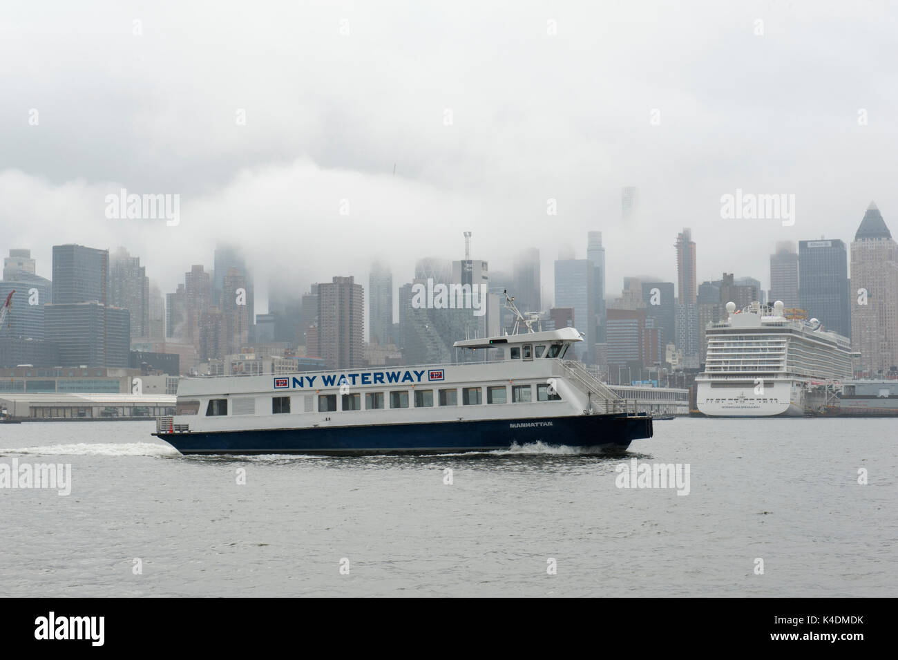 Ein New York Waterway ferry Geschwindigkeiten über den Hudson River Vergangenheit die Wolkenkratzer von Manhattan an einem regnerischen Tag Anfang September. Stockfoto