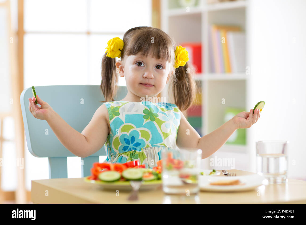 Kind Mädchen essen gesundes Gemüse in Kindergärten Stockfoto