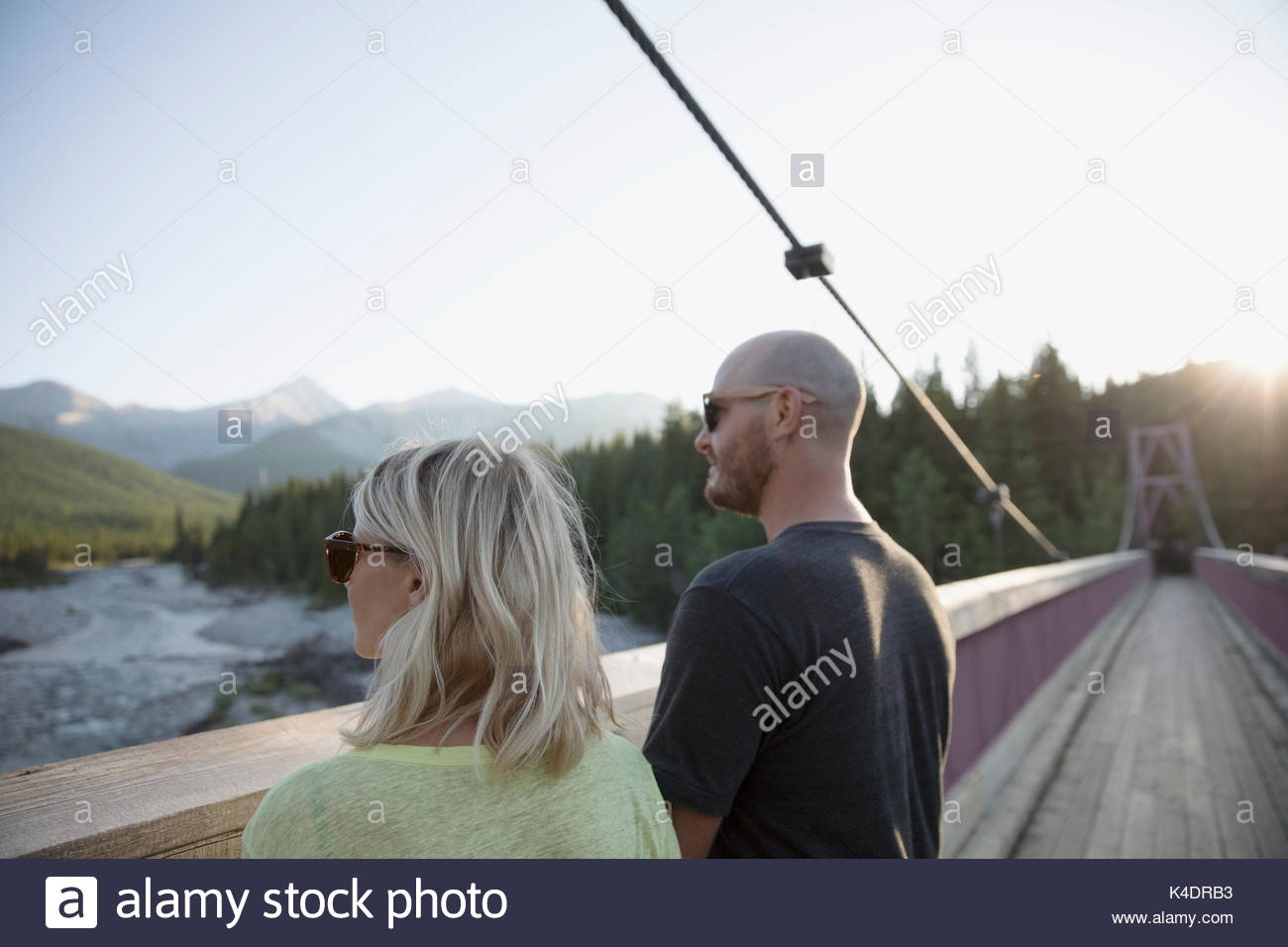Paar auf Holz Fußgängerbrücke am Blick in den Wäldern auf der Suche Stockfoto