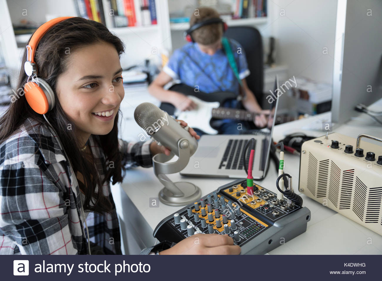 Lächelnd Jugendmädchen mit Kopfhörern singen, Aufnehmen von Musik am Mikrofon Ausrüstung Stockfoto