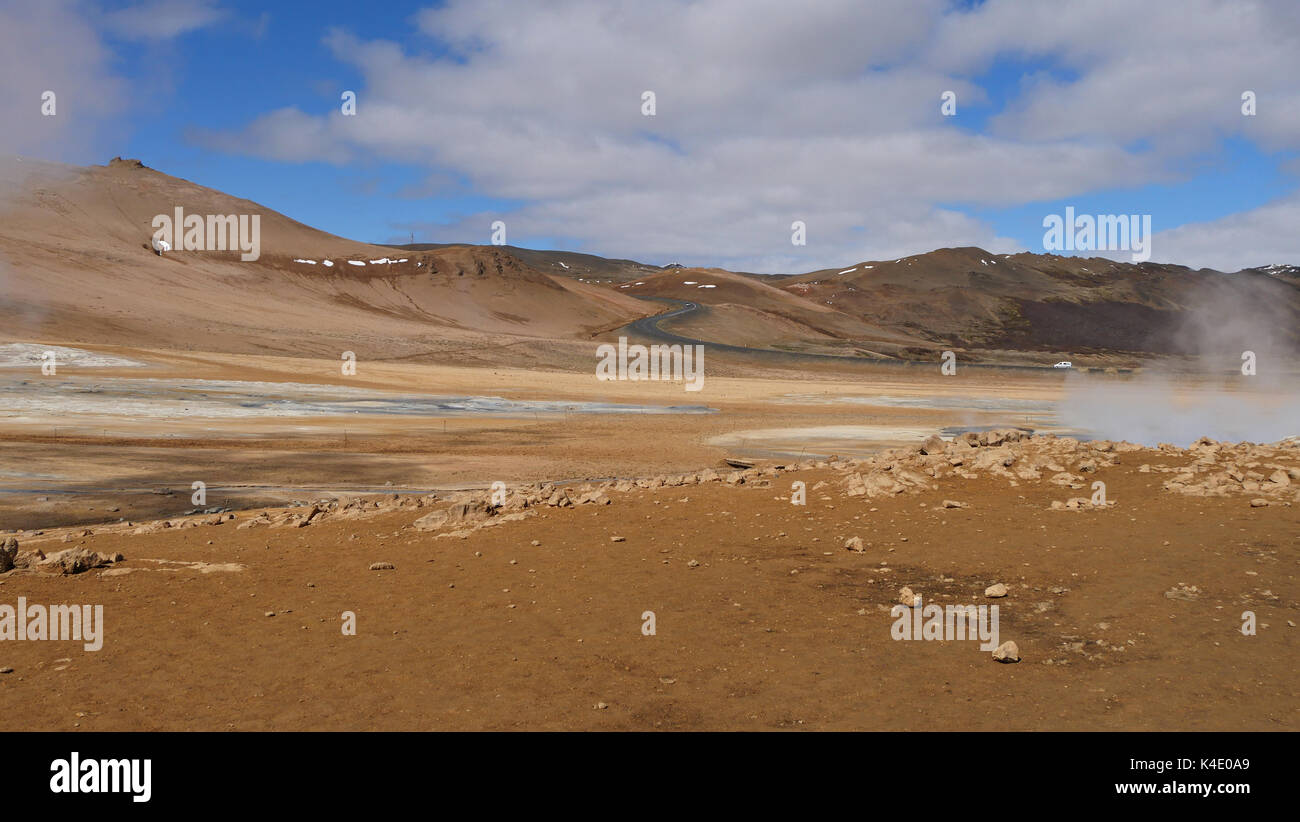 Namafjall, Island, Dampfende Schwefelquellen. Eine Straße führt hinunter in den Krater auf die Ebene der dampfenden Sulphur Springs Stockfoto Namafjall, Island, Dampfende Schwefelquellen. Eine Straße führt hinunter in den Krater auf die Ebene der dampfenden Sulphur Springs Stockfoto