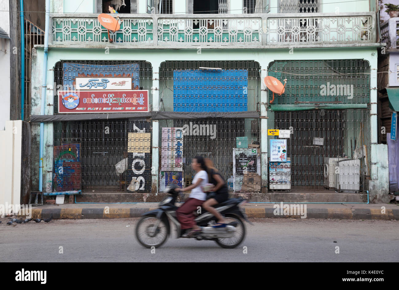 Die Mädchen Rennen durch die leeren Straßen von Sittwe auf Motorrad, Rakhine, Myanmar Stockfoto