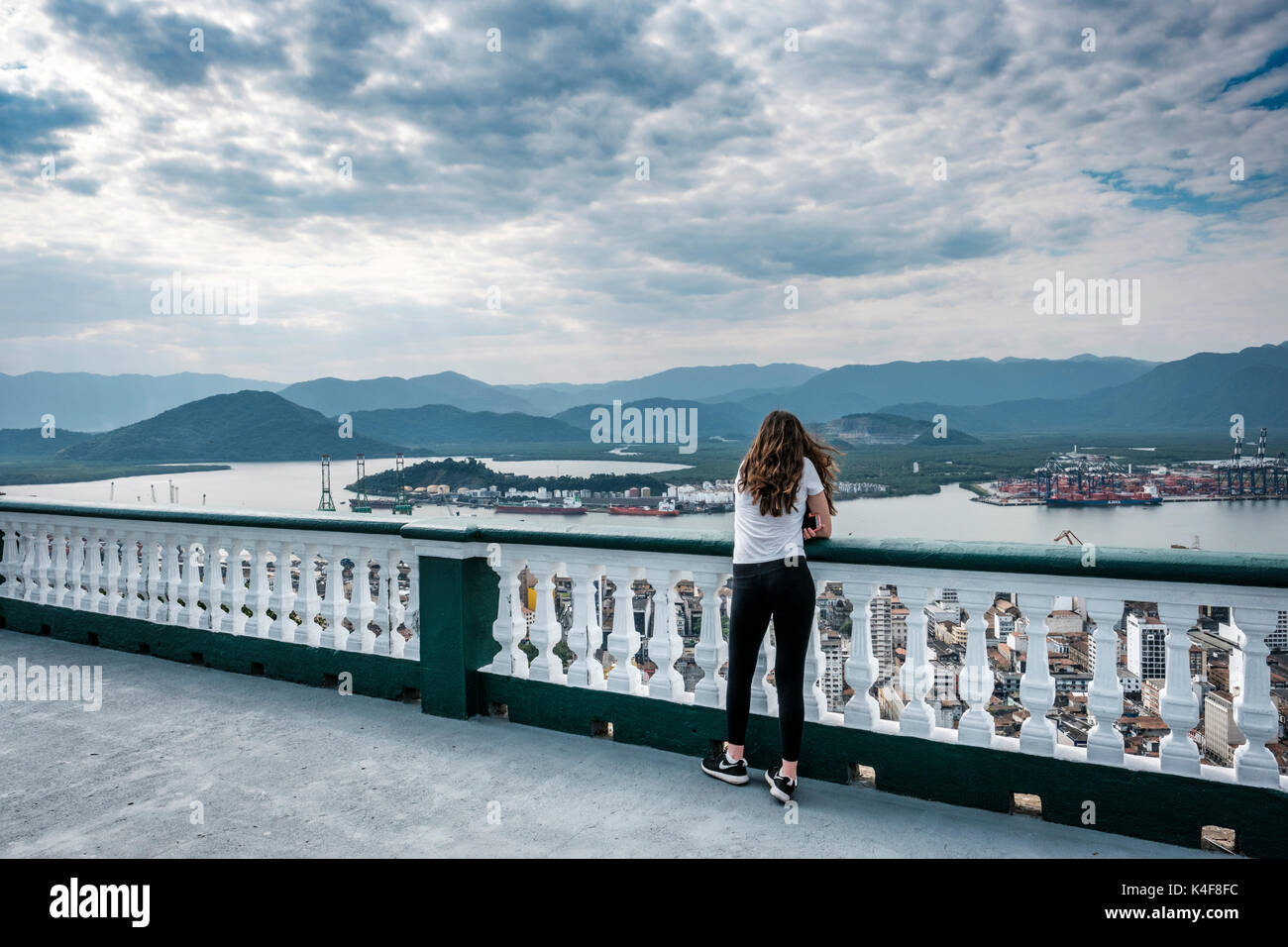 Teenagerin, die die malerische Aussicht vom Gipfel des Monte Serrat mit Blick auf den Hafen von Santos, Bundesstaat Sao Paulo, Brasilien, zu schätzen weiß. Stockfoto