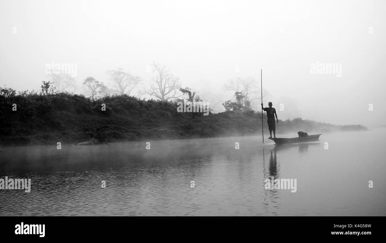 Reflexion: man Rudern auf dem Schiff in der nebligen Wald am Narayani Fluss in Nepal Chitwan Nationalpark Regenwald Stockfoto