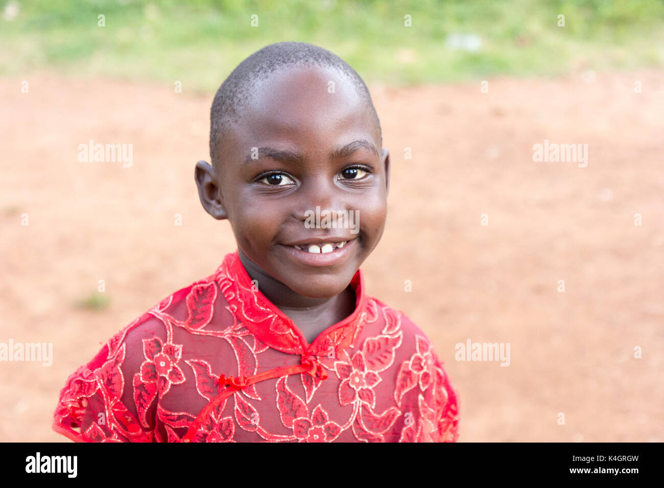 Eine schöne kleine Ugandischen schwarze Mädchen in roter Seide Bluse angezogen Stockfoto