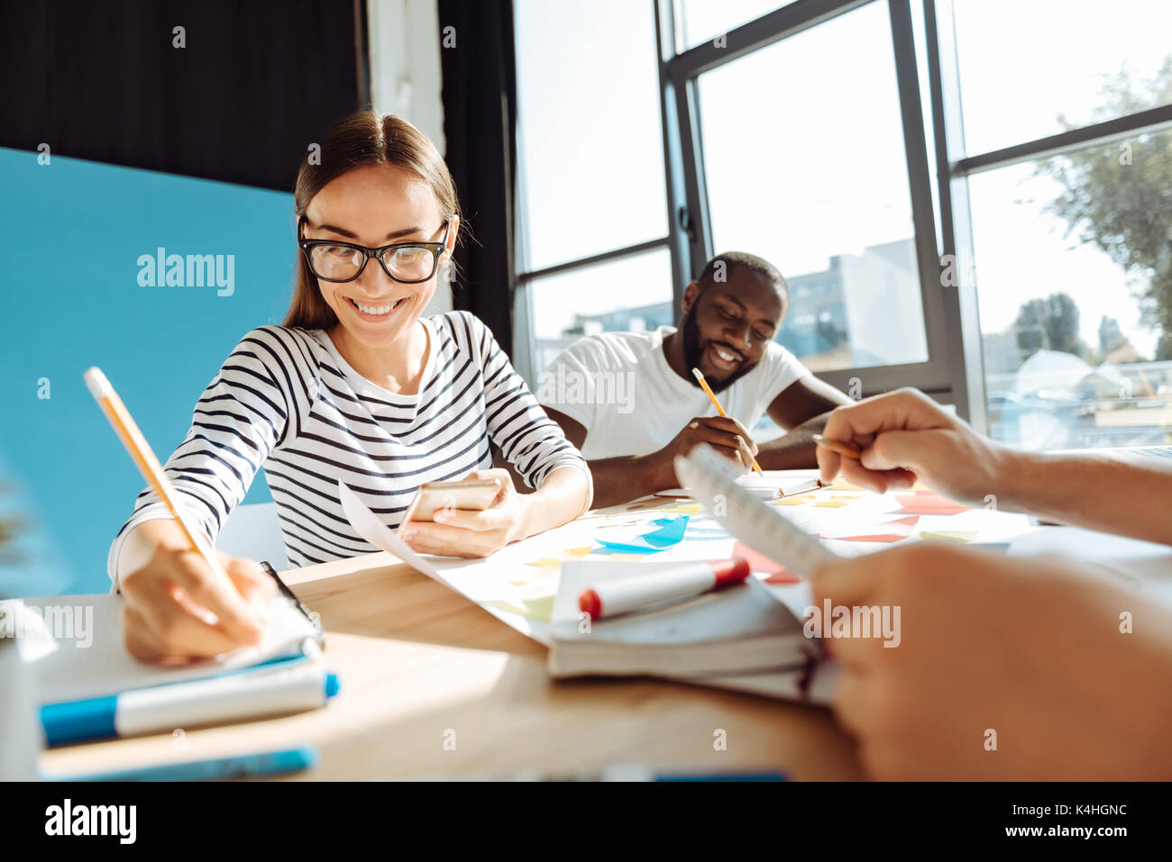 Freundliche Studentin immer bereit für die Prüfung mit Ihrem groupmates Stockfoto