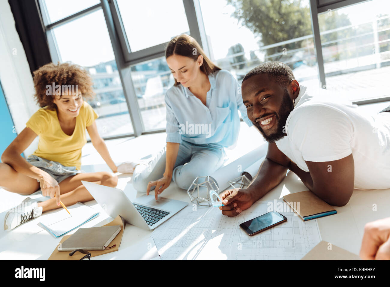 Positive internationale Studenten studing auf dem Boden Stockfoto