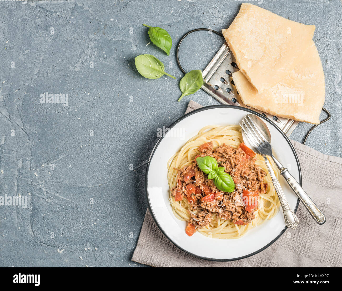 Pasta Dinner. Spaghetti Bolognese in der Metall Platte mit Parmesan, reibe und frischem Basilikum über grauer Beton Hintergrund Stockfoto