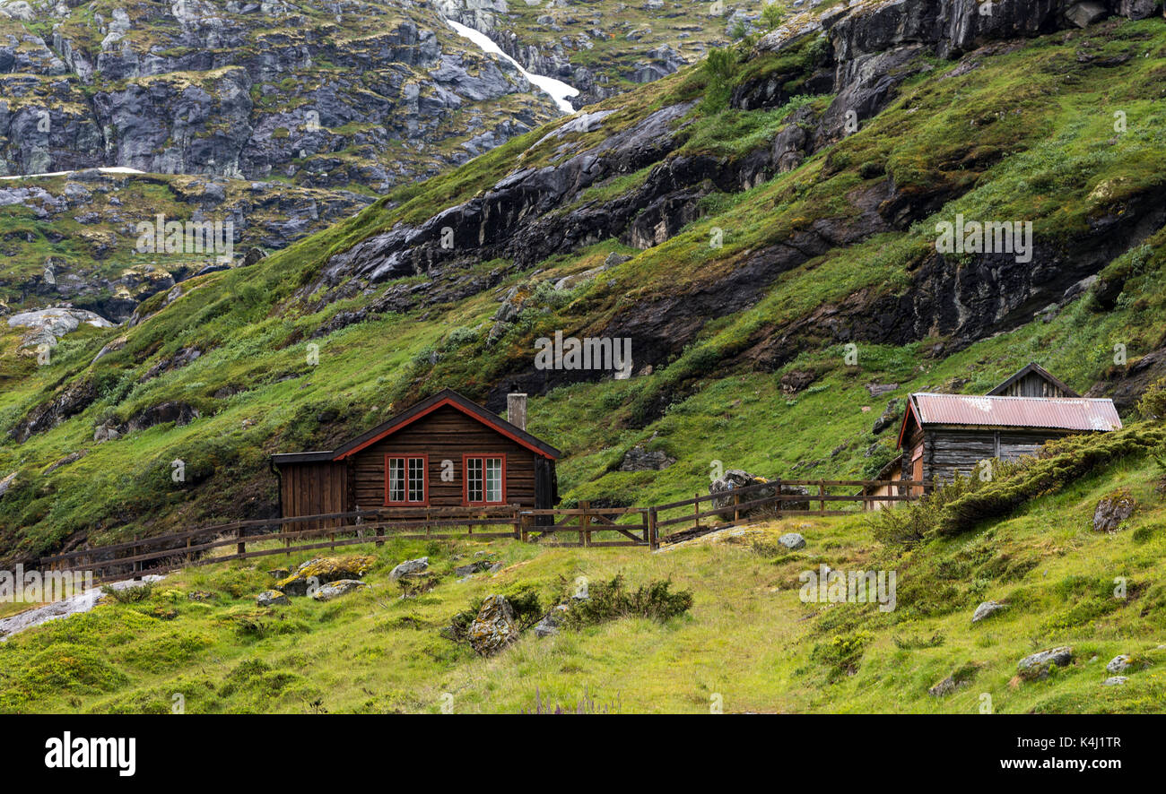 Hölzerne Haus auf den Hügeln des Jostedalsbreen Natur Park im Sommer mit Schnee auf den Bergen Stockfoto