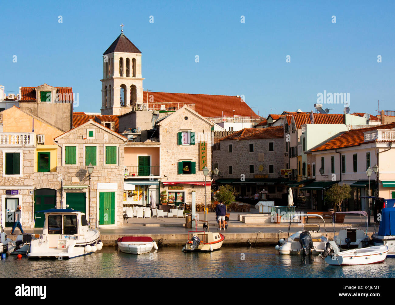 Vodice, Kroatien - 22. August 2017: Sonniger Morgen in kleinen mediterranen Stadt mit Häusern aus Stein und alten Kirchturm. Mit angelegten Boote auf der d Stockfoto