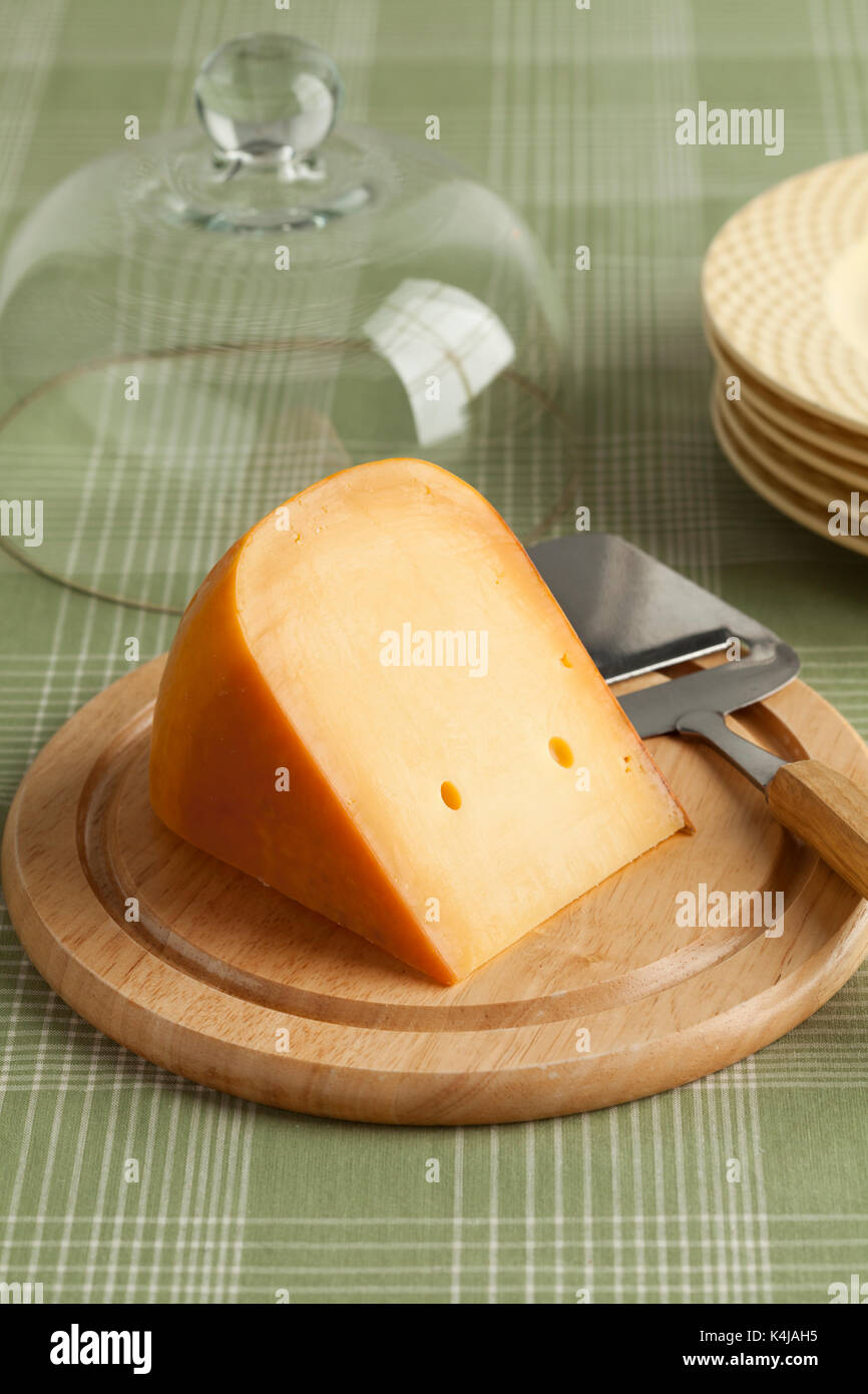 Stück der Niederländischen Gouda Käse auf einem Holzbrett beim Frühstück Stockfoto