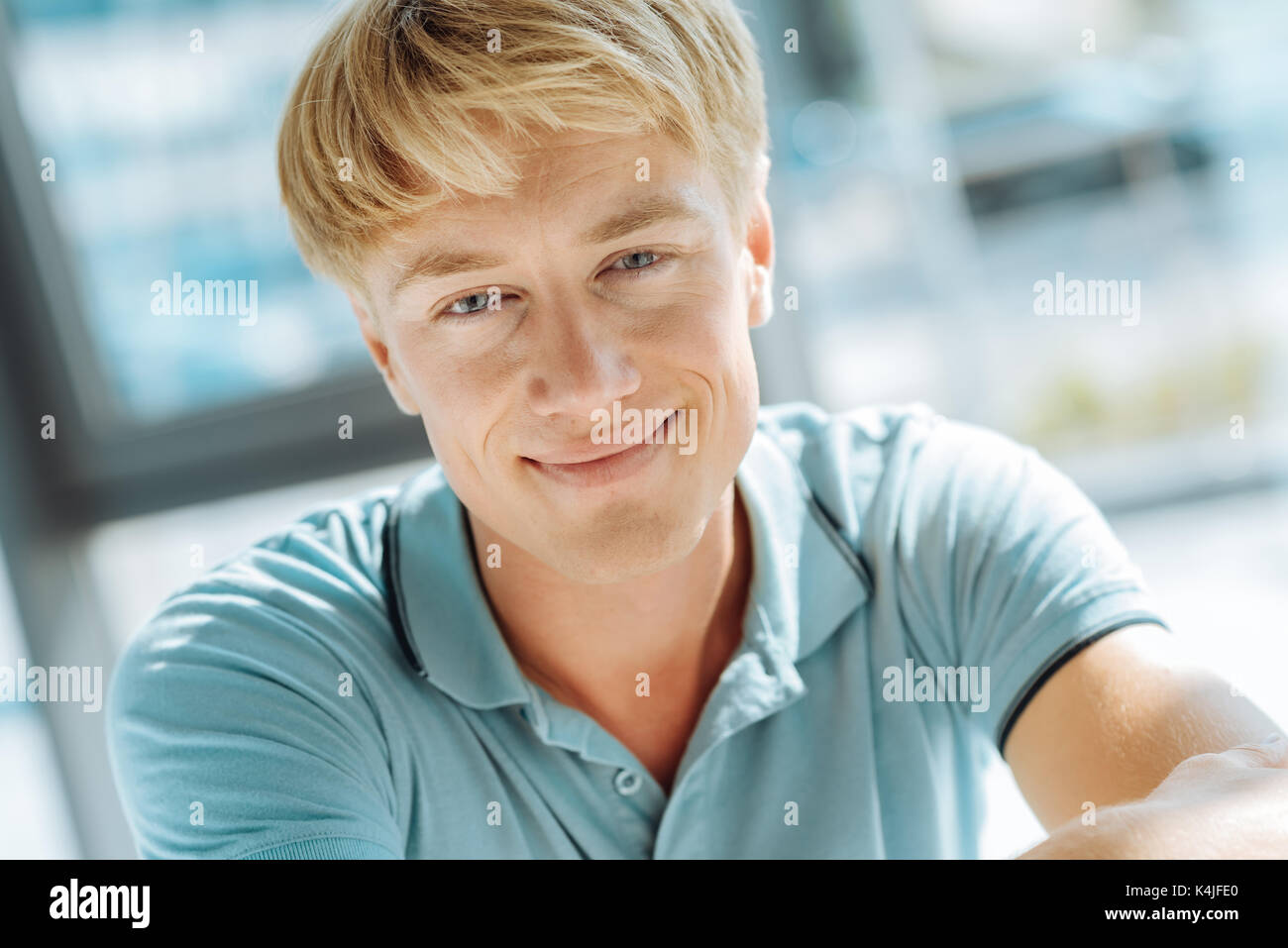 Nahaufnahme des aufrichtigen jungen blonden Mann lächelnd Stockfoto