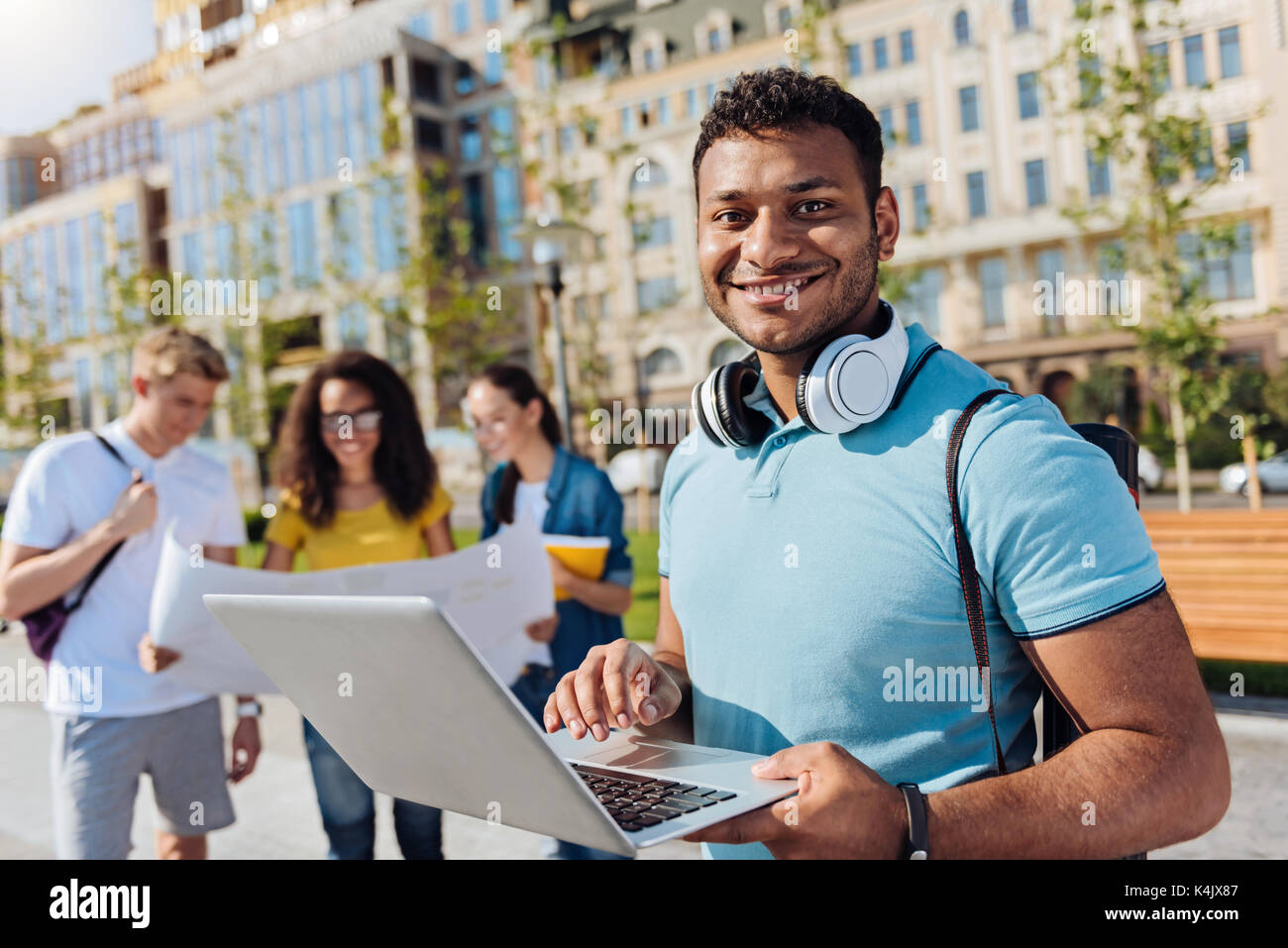 Positive internationale Student mit seinem Laptop Stockfoto