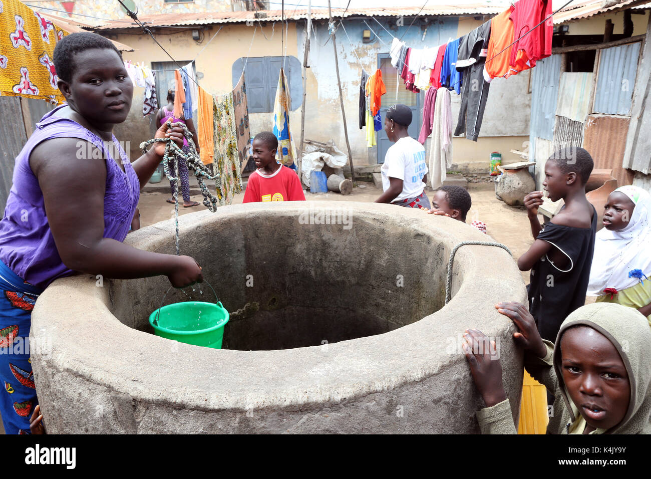 Eine Frau zieht Wasser aus einem Brunnen, Lome, Togo, Westafrika, Afrika Stockfoto