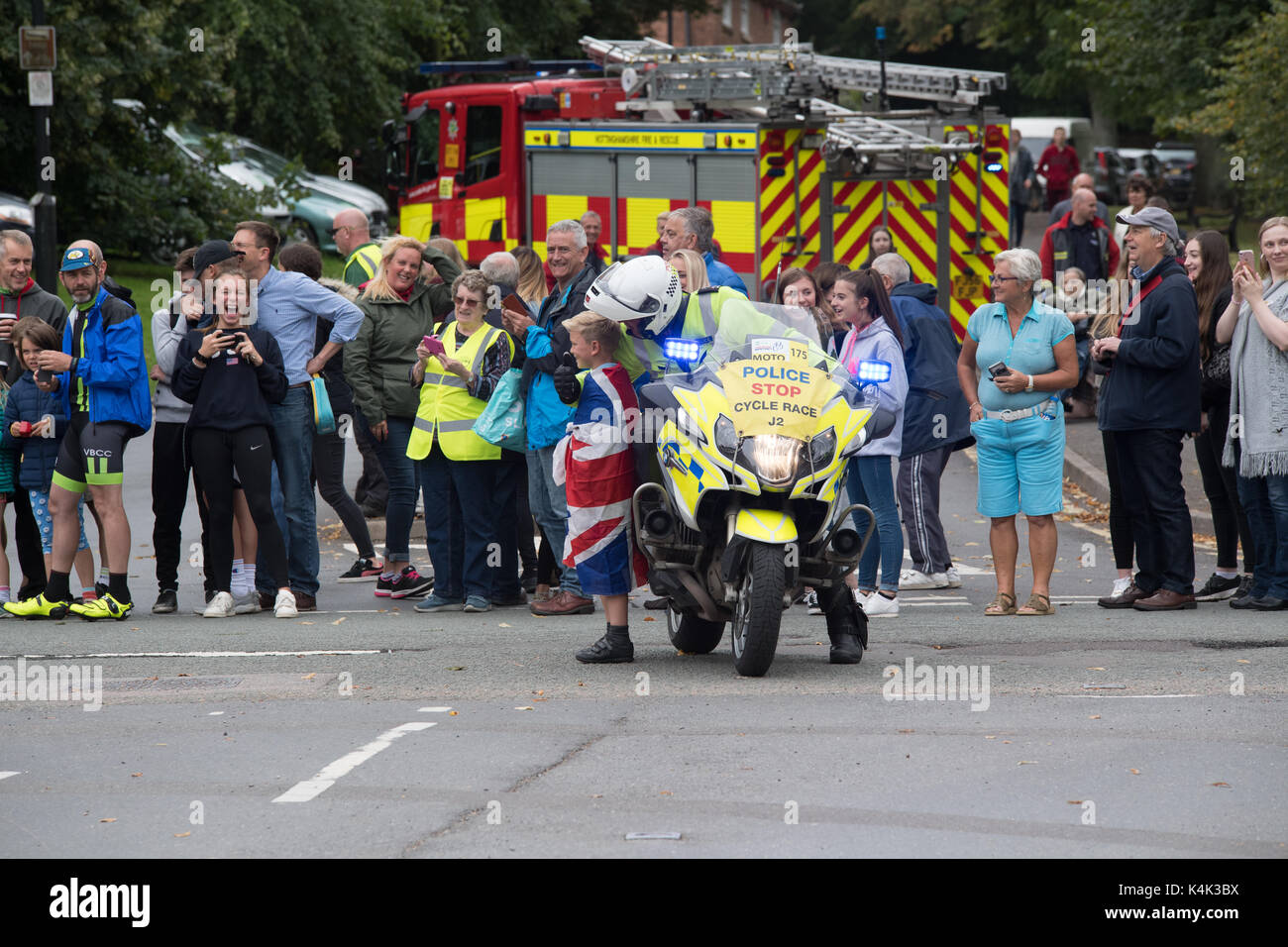 Tour durch Großbritannien Radrennen durchläuft in der Nähe von Newark in Nottinghamshire in Southwell Großbritannien am 6. September 2017. Bild zeigt Polizei Motorradfahrer mit kleinen Kind im Union Jack Flagge für ein Foto posiert gewickelt. credit Steve brownley/alamy leben Nachrichten Stockfoto