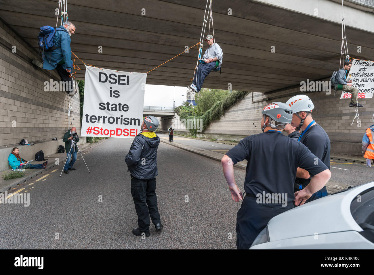 September 5, 2017 - London, UK - London, UK. 5. September 2017. Eine spezielle Polizeieinheit schaut auf die Demonstranten nach unten hängend an strickleitern von einer Brücke die Straße in den größten Arme fair in den Londoner Docklands und Wunder statt der Welt zu blockieren, wie Sie sicher zu entfernen. Die "Kein Vertrauen in Krieg" Tag war eine Reihe von Veranstaltungen, die von verschiedenen Glauben Gruppen organisiert. Bevor ich ankam hatte es einen Lock-in auf der Zufahrtsstraße stoppen Lieferungen auf der Messe über das Tor zu setzen. Dies wurde durch einen Quaker Meeting an der Seite der Straße, bei dem eine Reihe von Personen stand oder saß b gefolgt Stockfoto