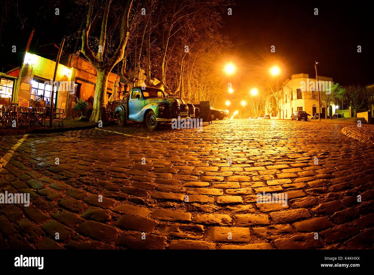 Oldtimer Autos auf der Straße mit Kopfsteinpflaster, Avenida Gral Flores in der Nacht, Colonia del Sacramento, Uruguay Stockfoto