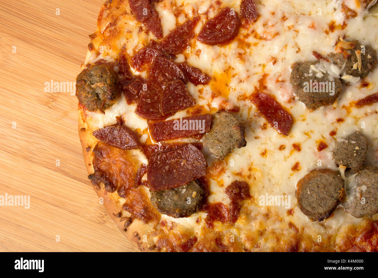 Salami und Wurst Pizza auf einer hölzernen pizza Peel oder Holz- Oberfläche, fettig und unordentliche Toppings Stockfoto