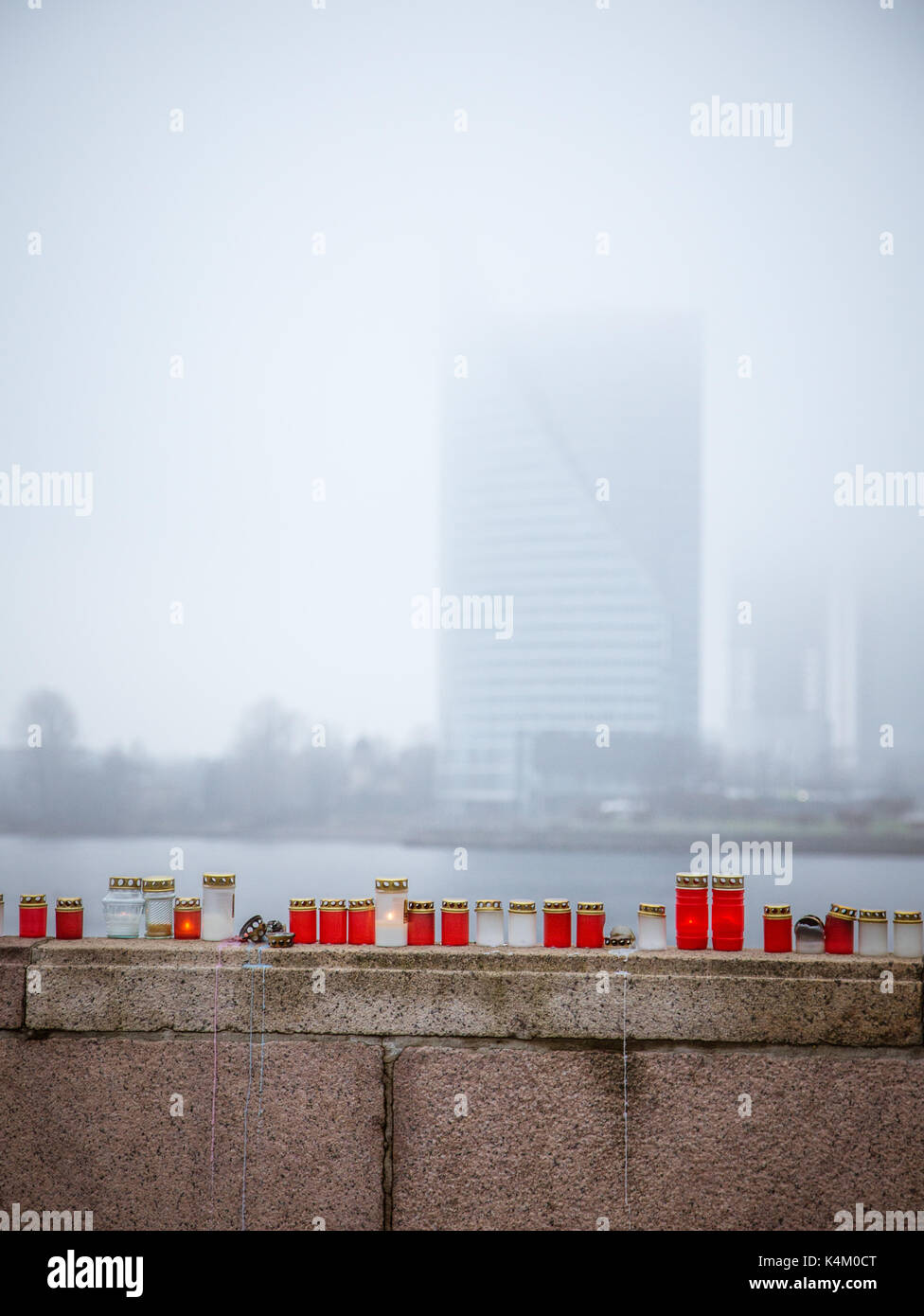 Einen schönen roten und weißen Kerzen auf das Geländer eines Flusses in der nebligen November Morgen in Riga Stockfoto
