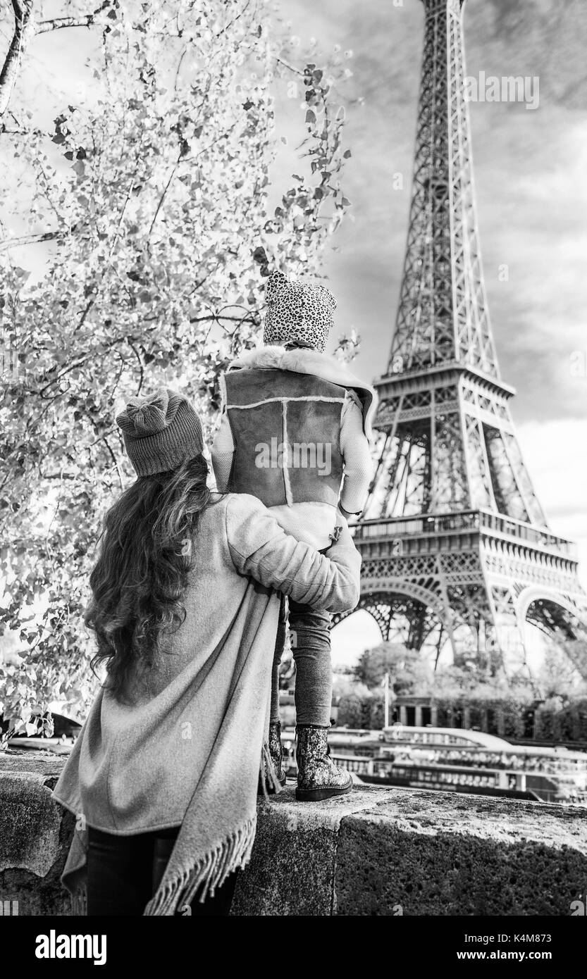 Herbst Kurzurlaube in Paris mit der Familie. Gesehen von hinten Mutter und Kind Reisende am Ufer in Paris, Frankreich am Eiffelturm Stockfoto