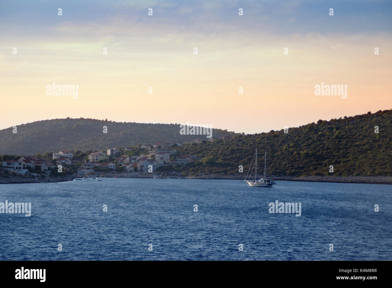 Segelboot in Blue Bay mit romantischen Stadt auf der Insel. Luxus Sail yacht, azurblaues Meer auf Reede. Stockfoto Segelboot in Blue Bay mit romantischen Stadt auf der Insel. Luxus Sail yacht, azurblaues Meer auf Reede. Stockfoto