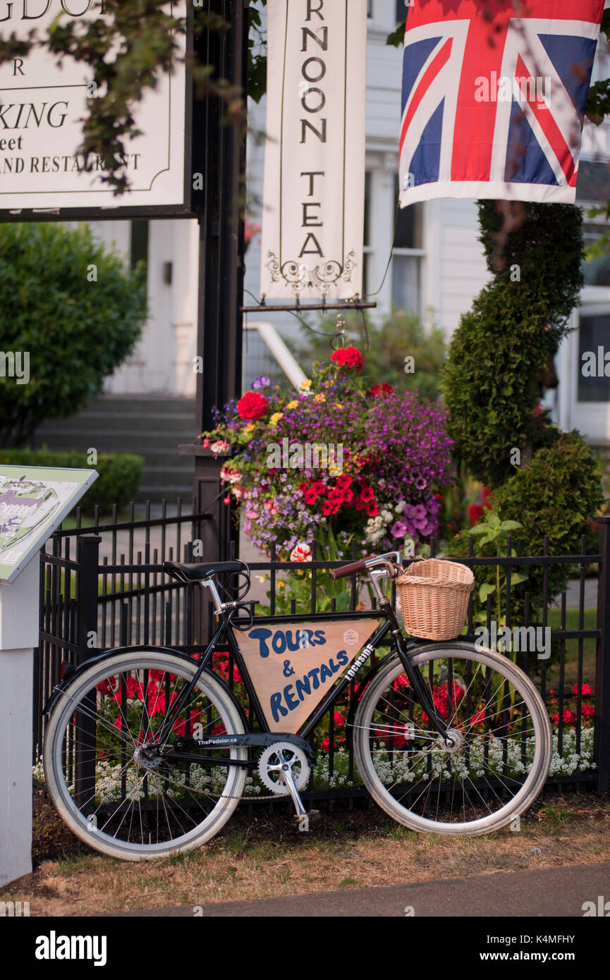 Huntingdon Manor Hotel, Victoria, British Columbia, Kanada. Union Jack Flagge, antike Fahrrad- und hängenden Blumenkörben werden angezeigt. Stockfoto