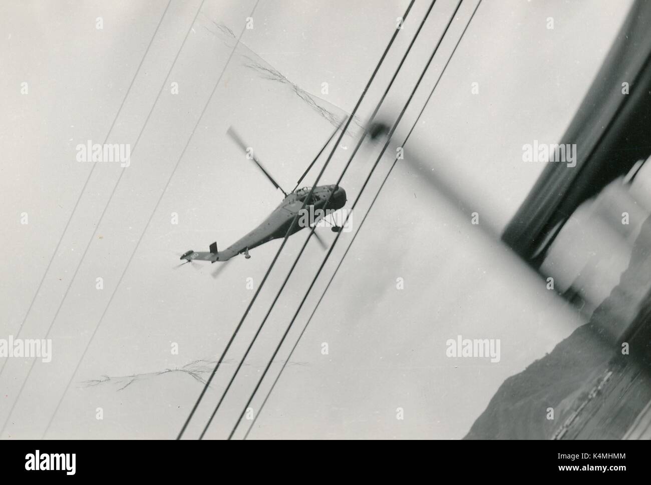 Ein United States Marine Corps Hubschrauber ist im Flug von einem bewegten militärischen Fahrzeug gesehen, mit Stromleitungen im Vordergrund, während des Vietnam Krieges, 1968. Stockfoto