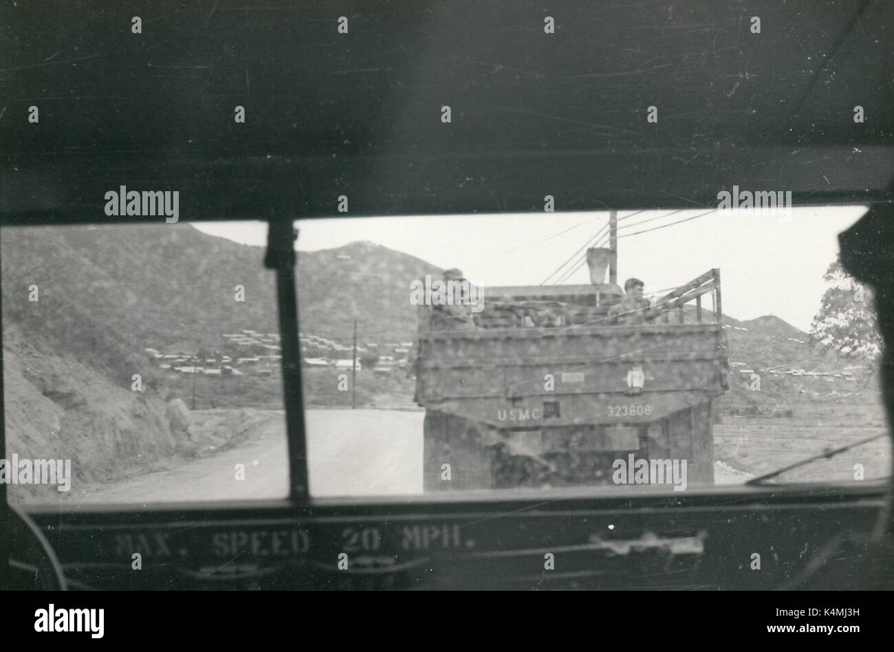 Ein United States Marine Corps militärisches Fahrzeug mit mehreren Soldaten sichtbar ist unten eine Straße auf eine Patrouille während des Vietnam Krieges fahren, durch das Fenster eines anderen militärisches Fahrzeug, 1968 gesehen. Stockfoto