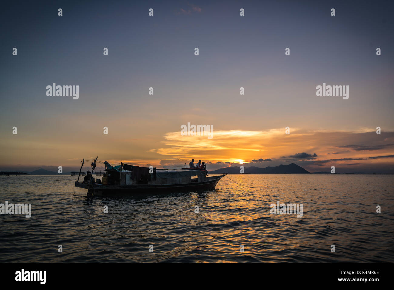Semporna, Sabah, Mai 2017, Golden Sunset mit Mann auf Boot Hintergrund Der bajau Stelzenhaus Stockfoto